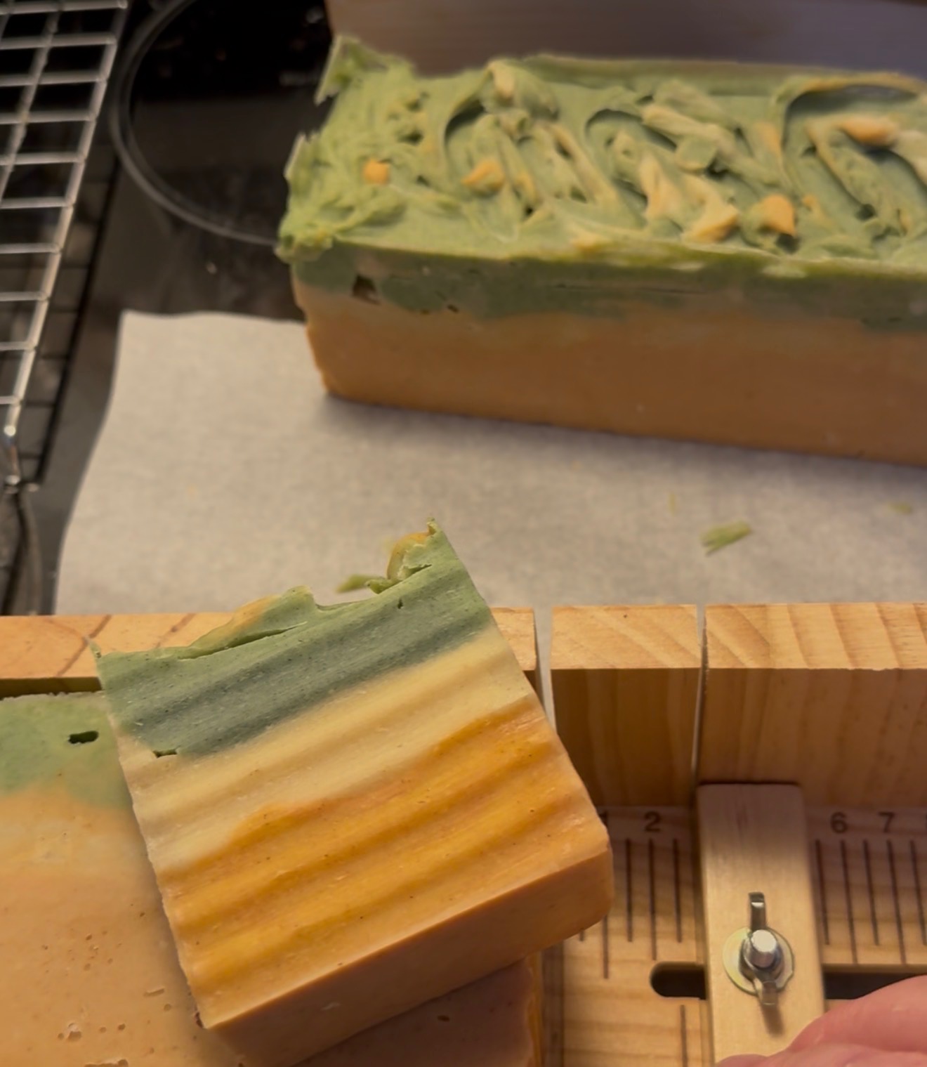 Freshly poured tallow soap loaf with green, golden, and orange swirl top