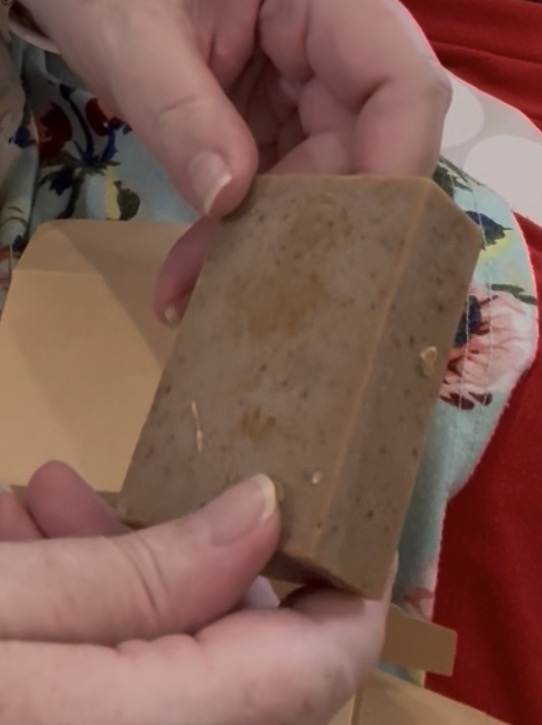 Handmade Almond Exfoliating tallow soap bar held in hand